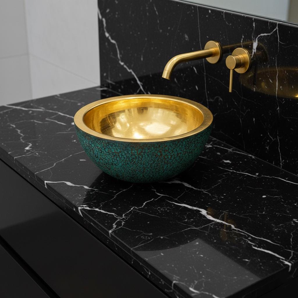 Gold sink and faucet on a black marble countertop