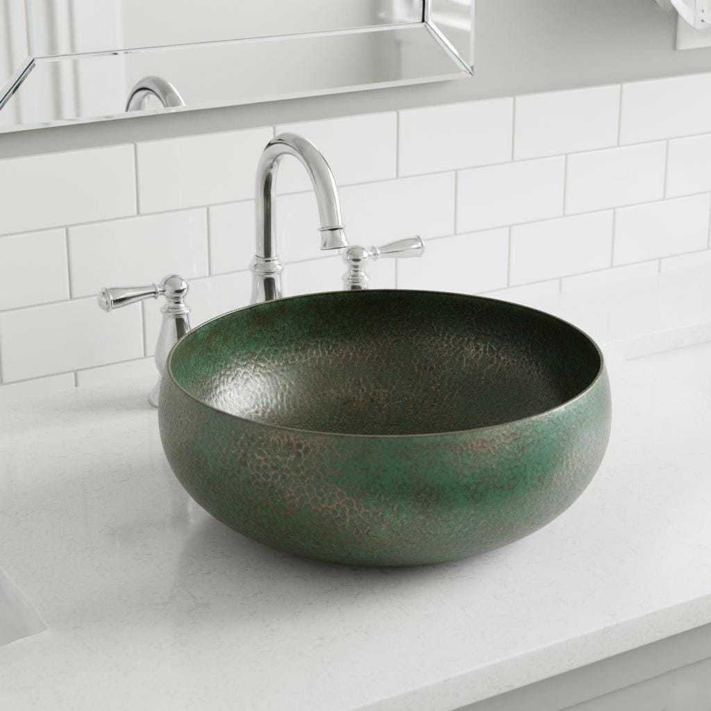 Green brass sink with silver faucet in a bathroom setting