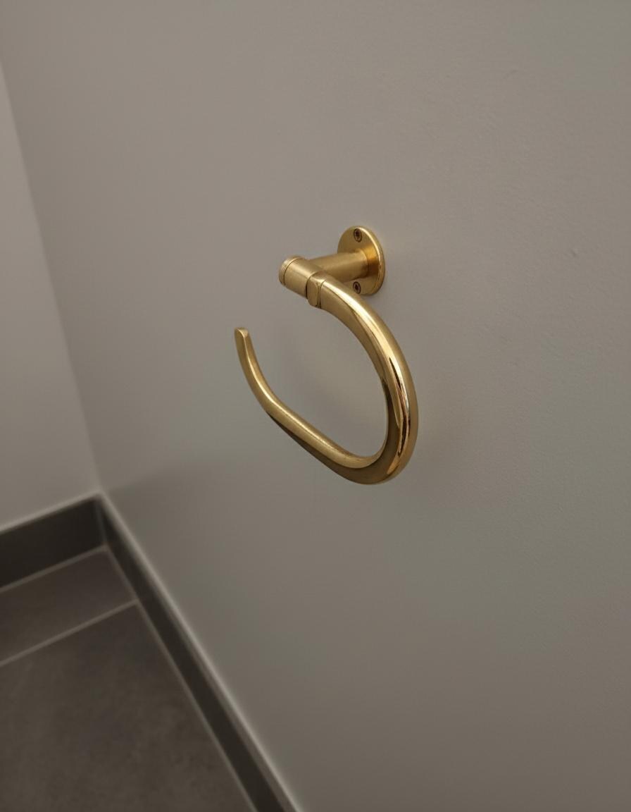 Gold towel hook on a gray wall