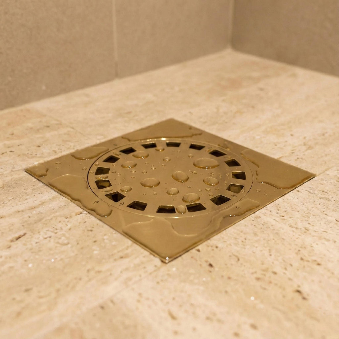 Metallic shower drain cover on a tiled bathroom floor