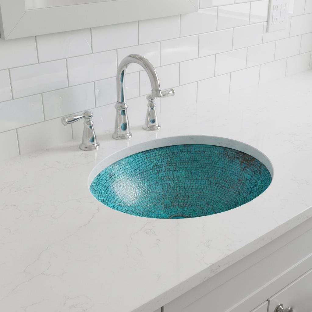 Bathroom sink with turquoise mosaic design and chrome faucet against a white tiled wall.