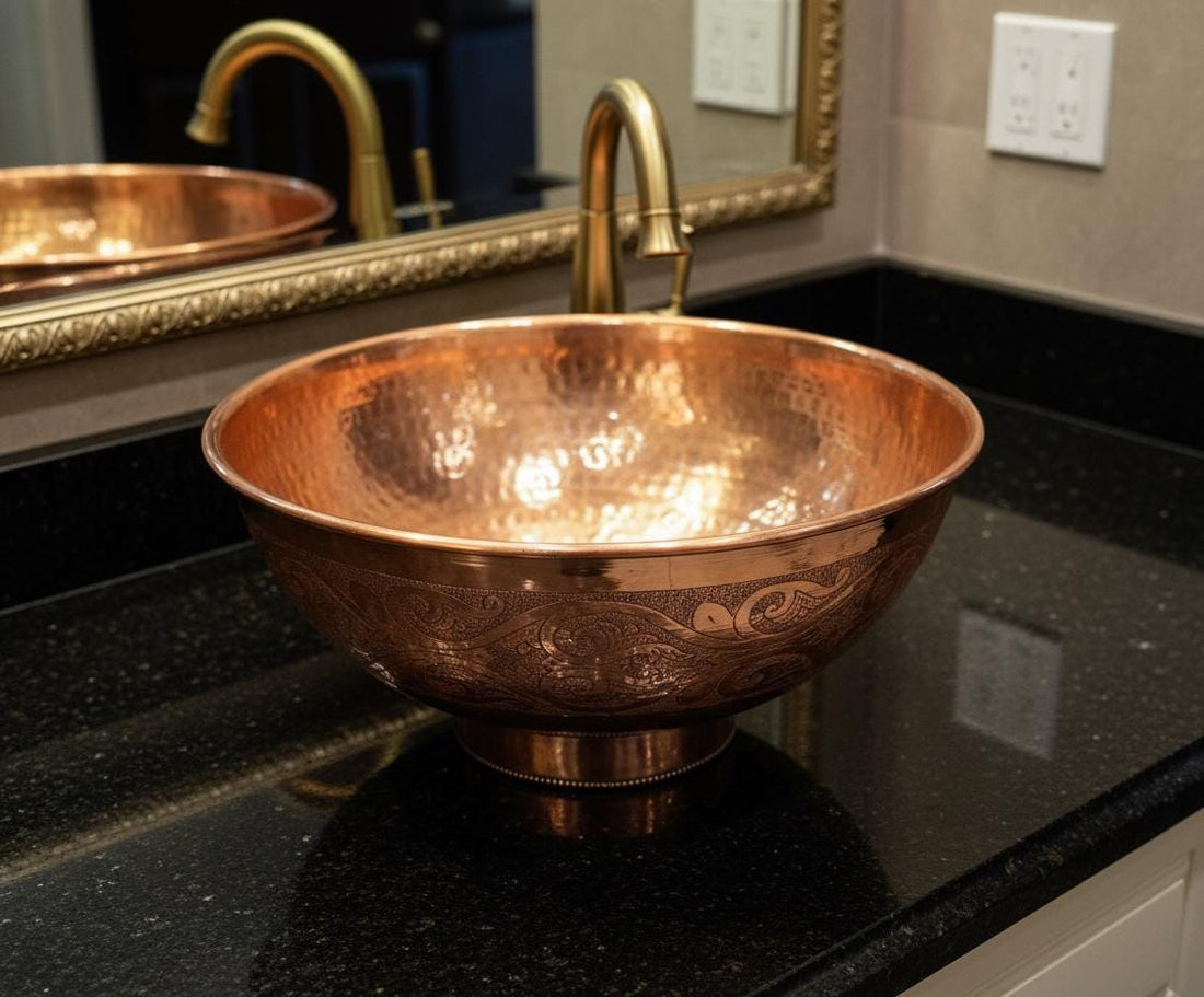 Copper sink on a black countertop with a mirror reflecting the scene.