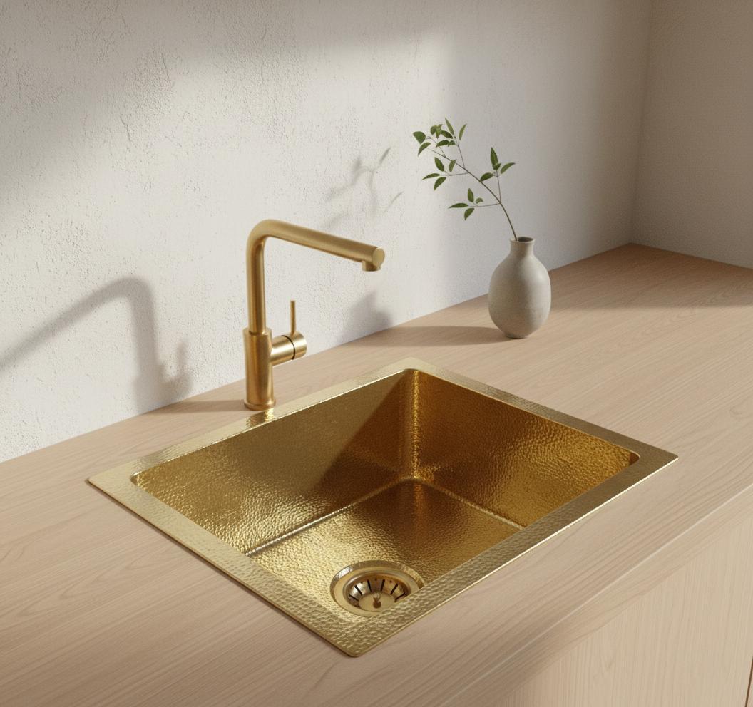 Gold kitchen sink with faucet on a wooden countertop
