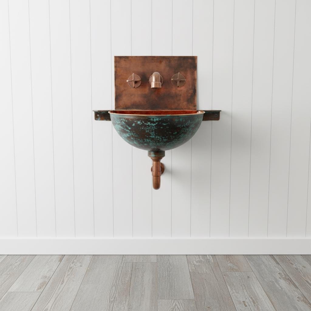 Wall-mounted copper sink with green patina against a white paneled wall.