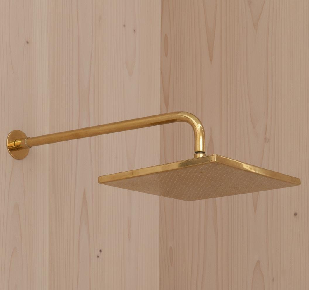 Gold shower head mounted on a wooden wall