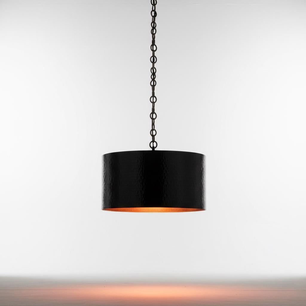 Black pendant light with a copper interior on a white wooden background