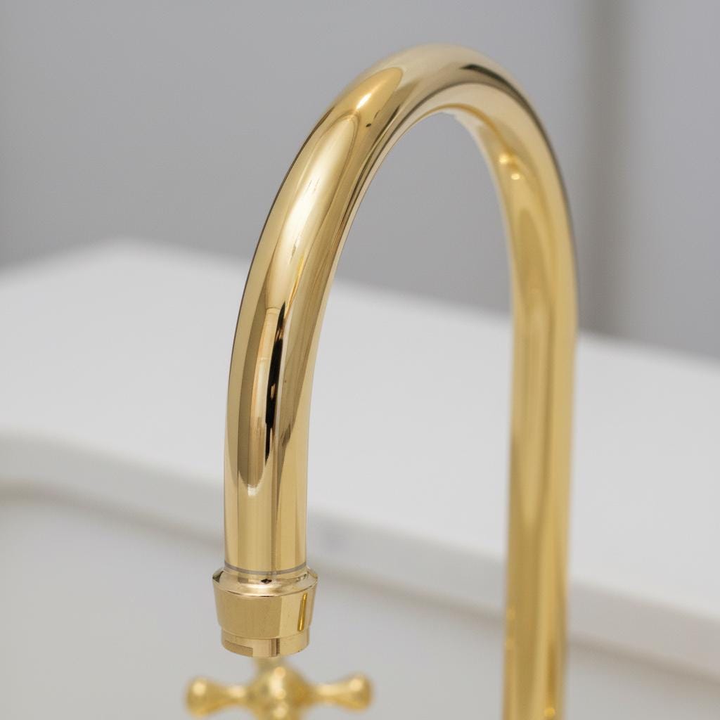 Gold kitchen faucet on a light gray background
