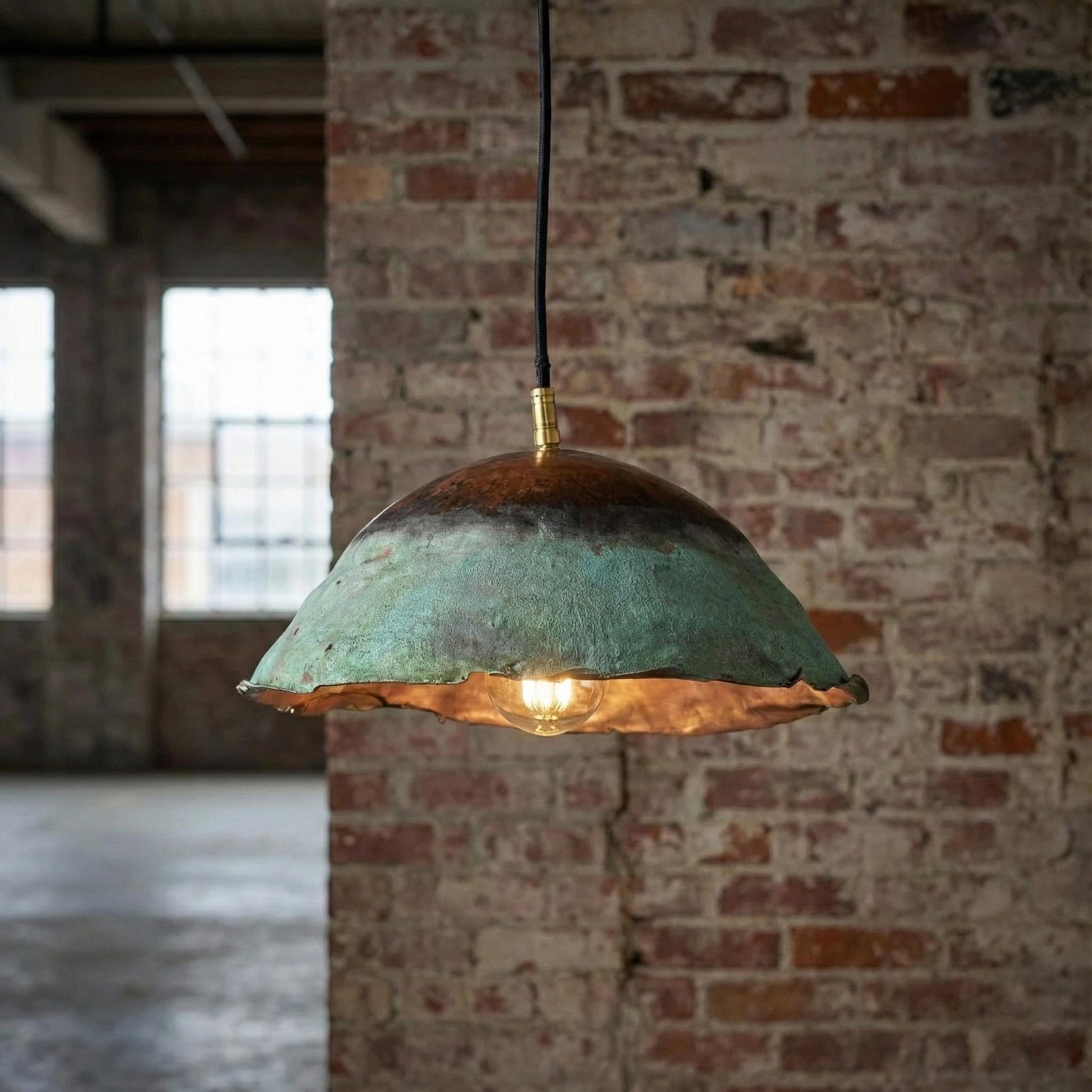 Vintage-style pendant light hanging against a brick wall.