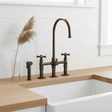Bronze kitchen faucet and handles on a wooden countertop with a white sink.