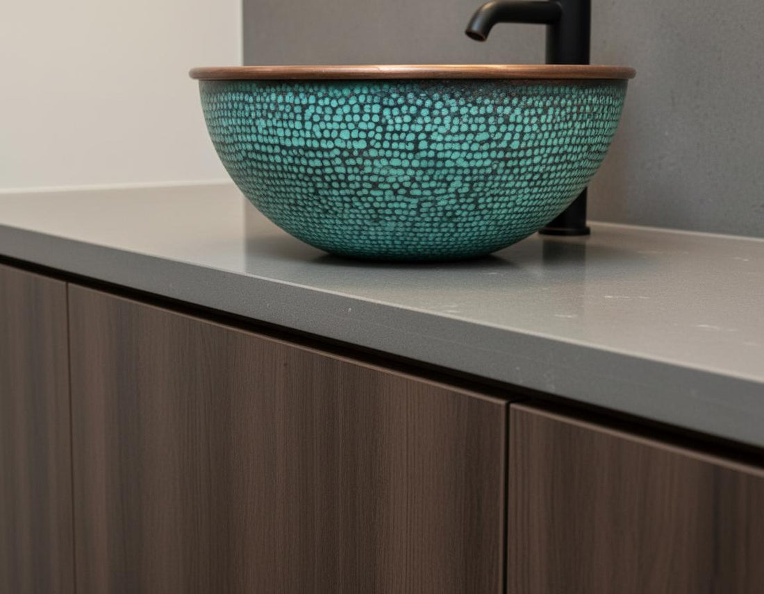 Bathroom vanity with a copper and green mosaic sink, wooden countertop, and tiled wall.