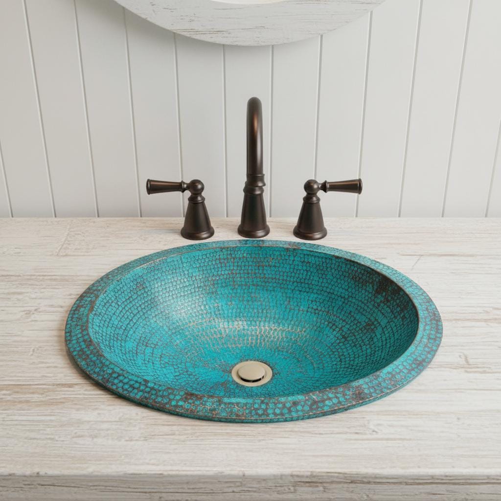 copper sink with bronze faucet and handles on a wooden countertop.