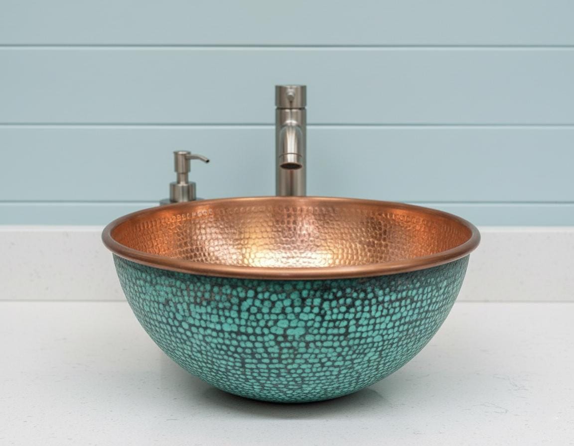 Copper and turquoise sink with faucet against a light blue wall.
