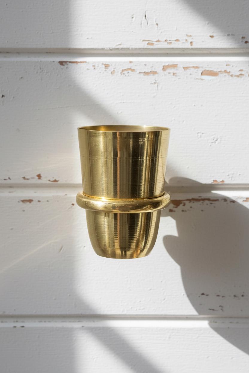Gold metal pot on a white surface with a textured background