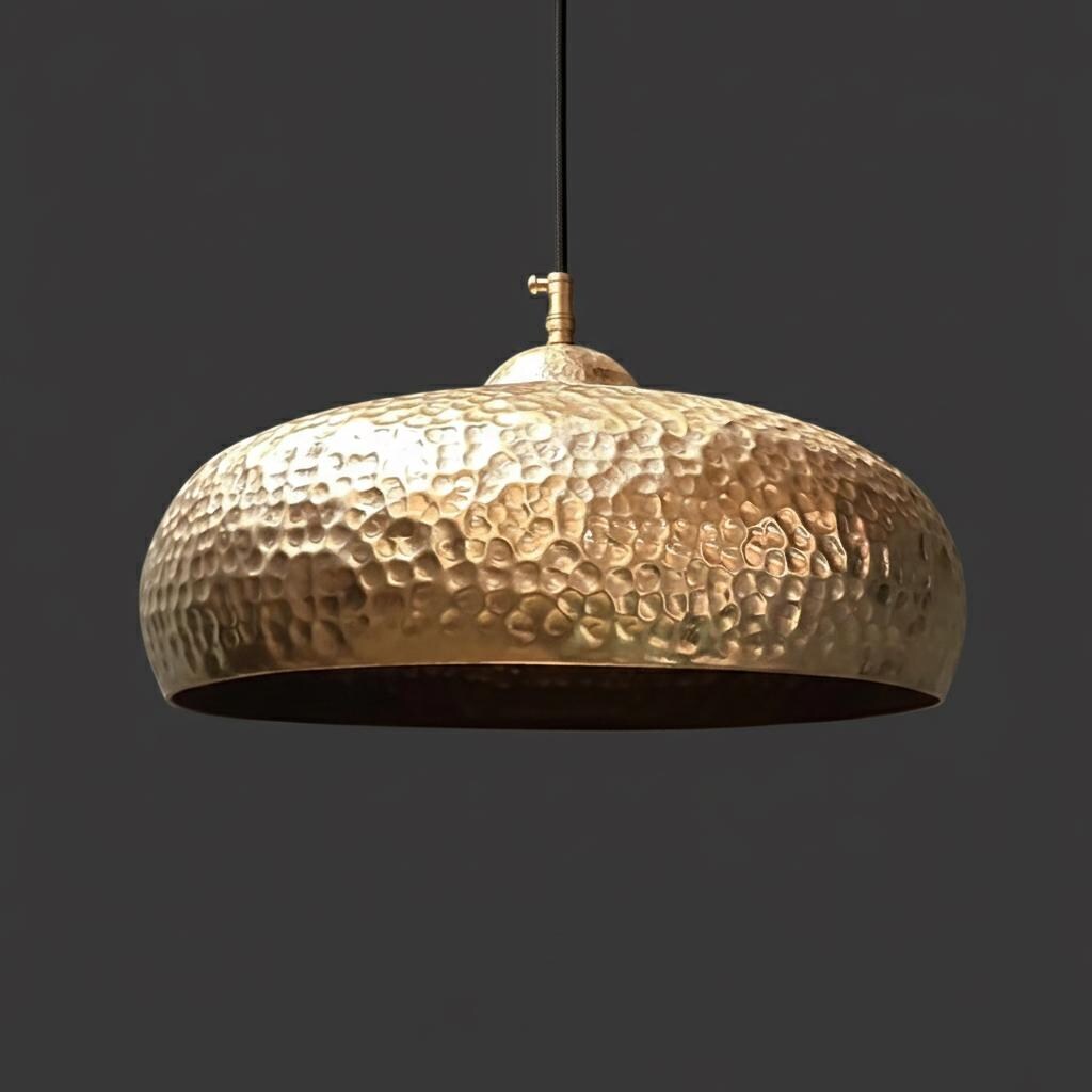 Gold pendant light with a textured surface on a dark background