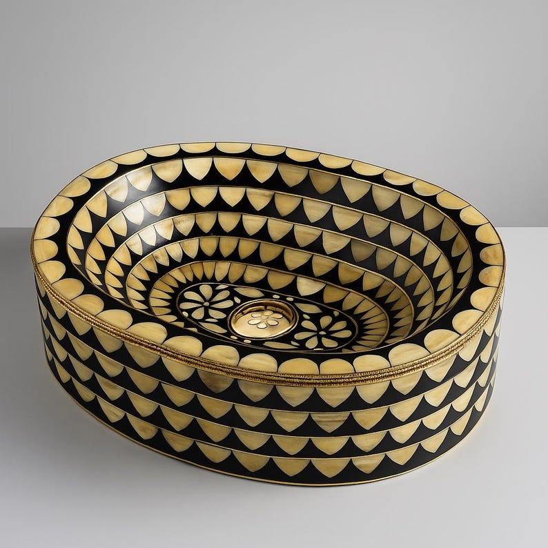 Artisan oval brass vessel sink with black, bone & resin inlay. Handcrafted for luxury bathrooms, spas, and designer vanities. Includes brass drain.

