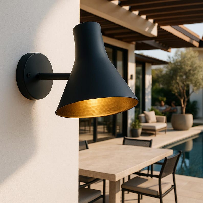 Handcrafted black wall sconce with hammered brass glow – artisan-made luxury fixture

