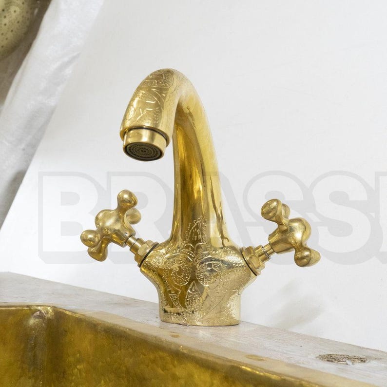 Handmade Moroccan brass bathroom faucet with engraved detail, dual handles, and gooseneck spout. Unlacquered brass ages with rich patina.

