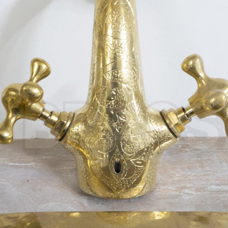 Handmade Moroccan brass bathroom faucet with engraved detail, dual handles, and gooseneck spout. Unlacquered brass ages with rich patina.

