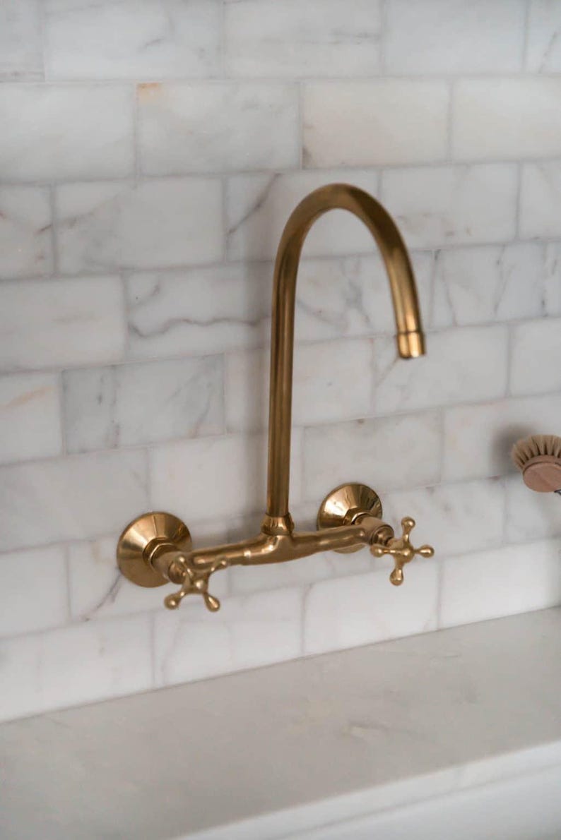 Handmade Moroccan wall-mount faucet in solid unlacquered brass with gooseneck spout and cross handles

