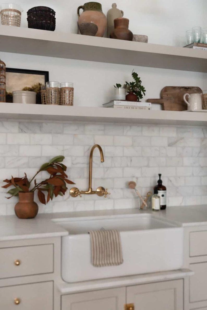Handmade Moroccan wall-mount faucet in solid unlacquered brass with gooseneck spout and cross handles

