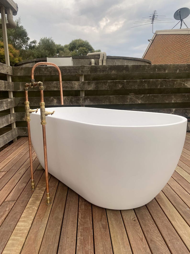 Handmade freestanding copper bath filler with brass taps

