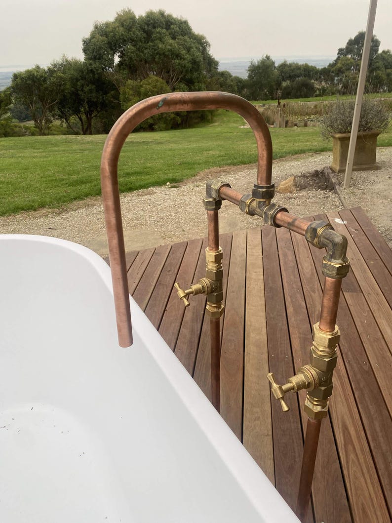 Handmade freestanding copper bath filler with brass taps

