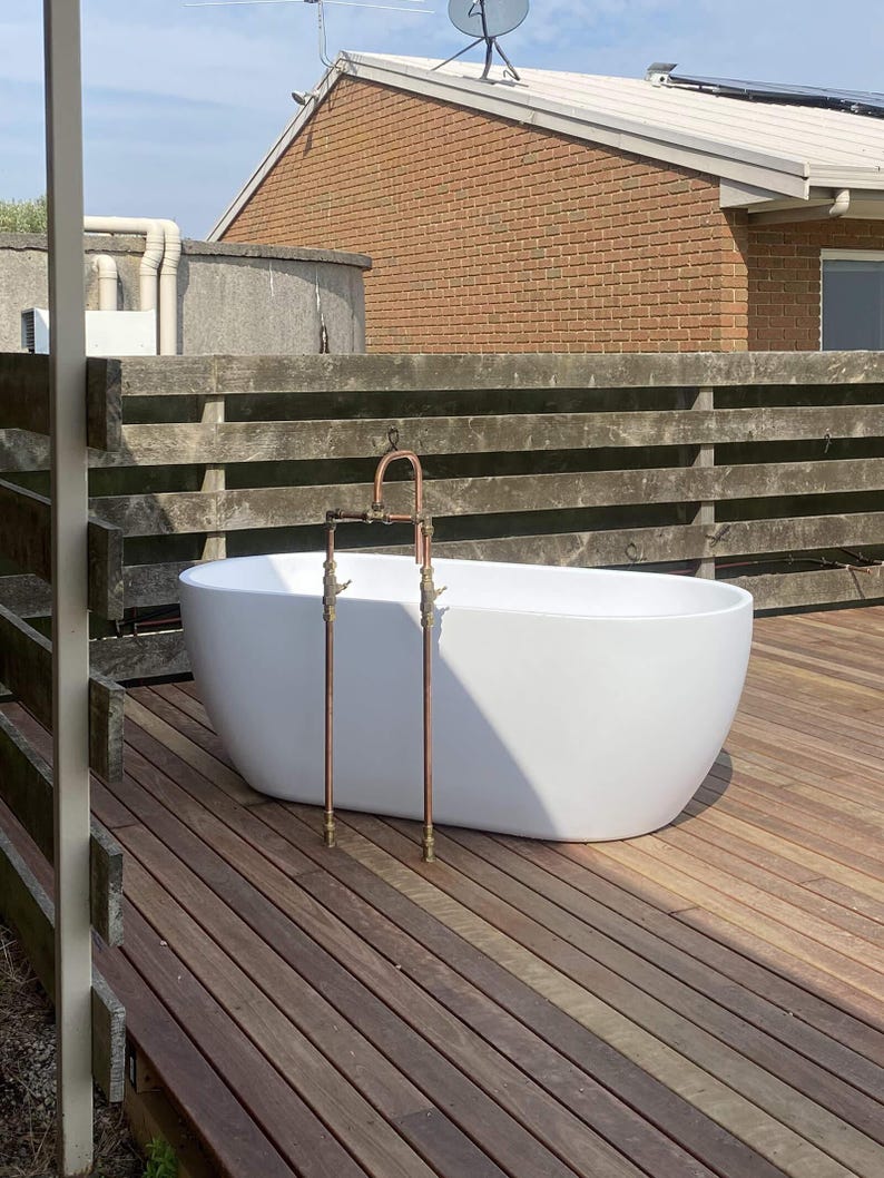 Handmade freestanding copper bath filler with brass taps

