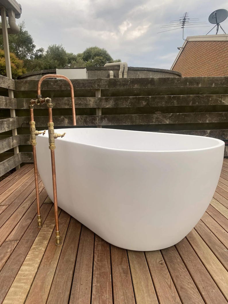 Handmade freestanding copper bath filler with brass taps

