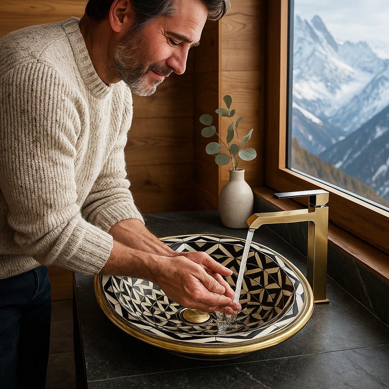 Handmade oval brass bathroom sink with bone and resin flower pattern inlay on black base


