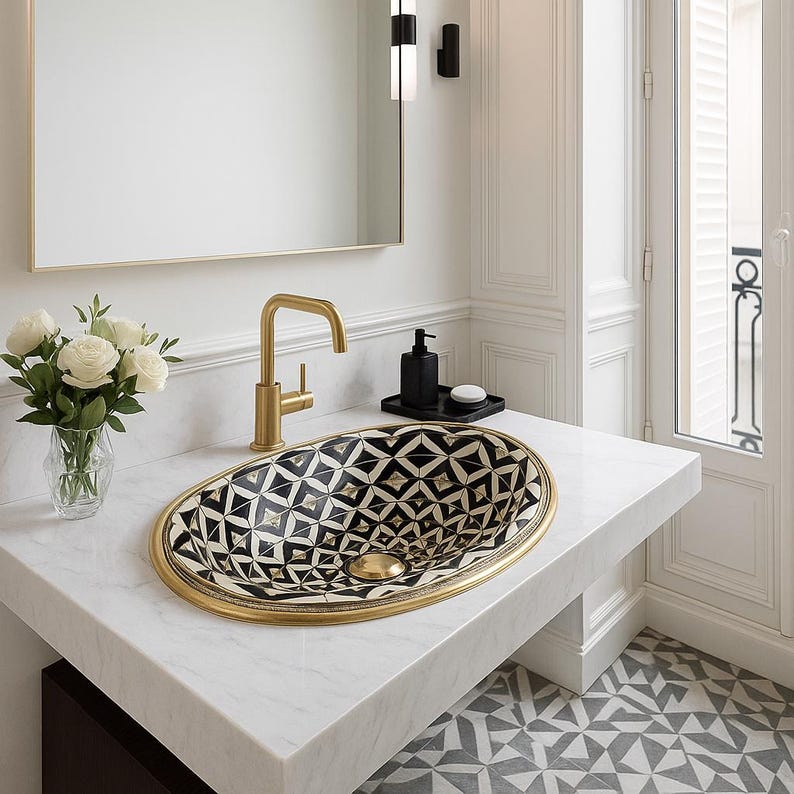 Handmade oval brass bathroom sink with bone and resin flower pattern inlay on black base

