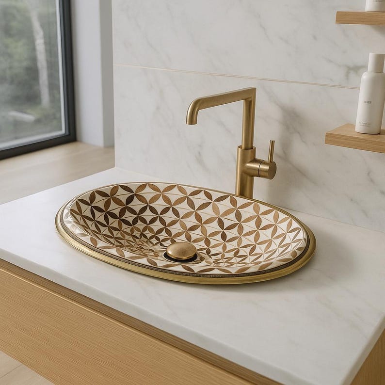 Handmade oval brass bathroom sink with bone and wood floral inlay on white base

