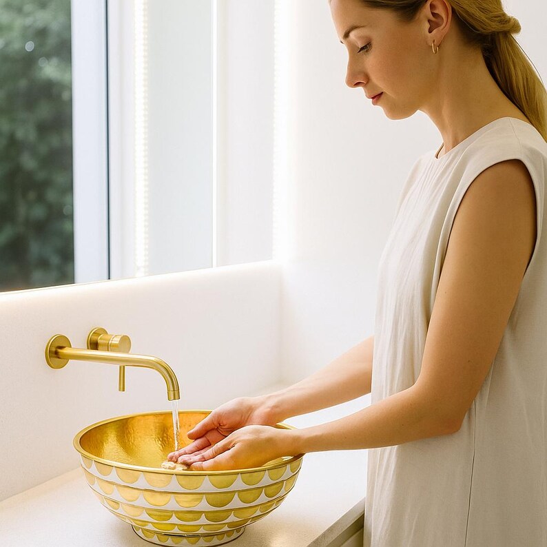 Handmade round brass vessel sink with hammered gold interior and ivory-toned wood inlays – countertop bathroom basin

