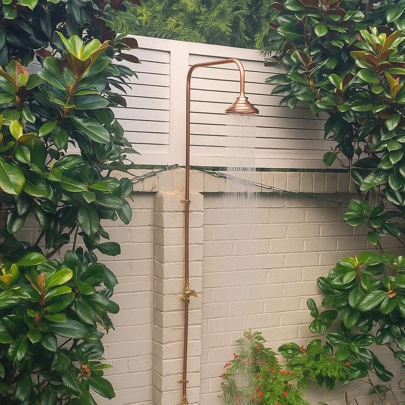 Minimalist copper and brass outdoor shower with natural patina finish

