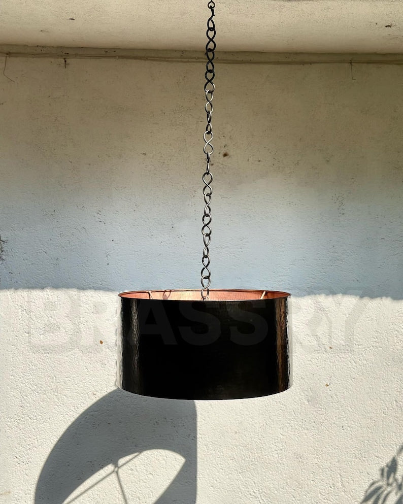 Black hammered copper pendant light with raw copper interior for kitchen or bar

