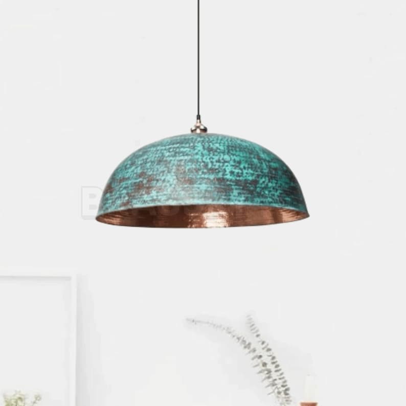 Rusted Moroccan hammered copper pendant light over kitchen island
