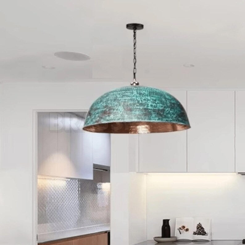 Rusted Moroccan hammered copper pendant light over kitchen island
