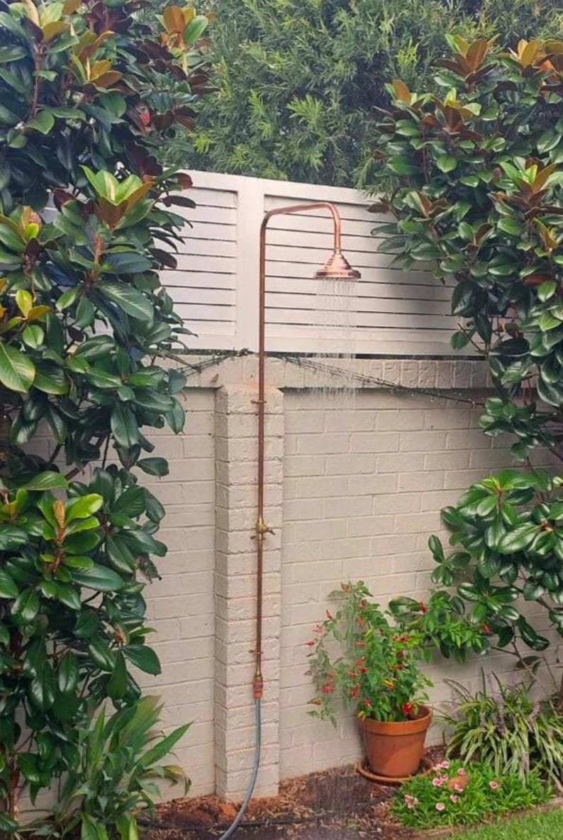 Rustic copper outdoor shower fixture for modern backyard bathrooms


