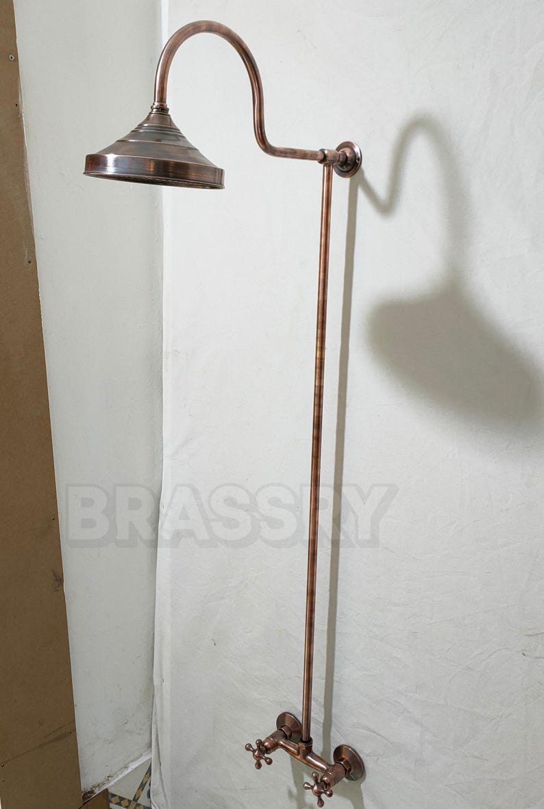 Wall-mounted copper shower fixture with brushed patina finish


