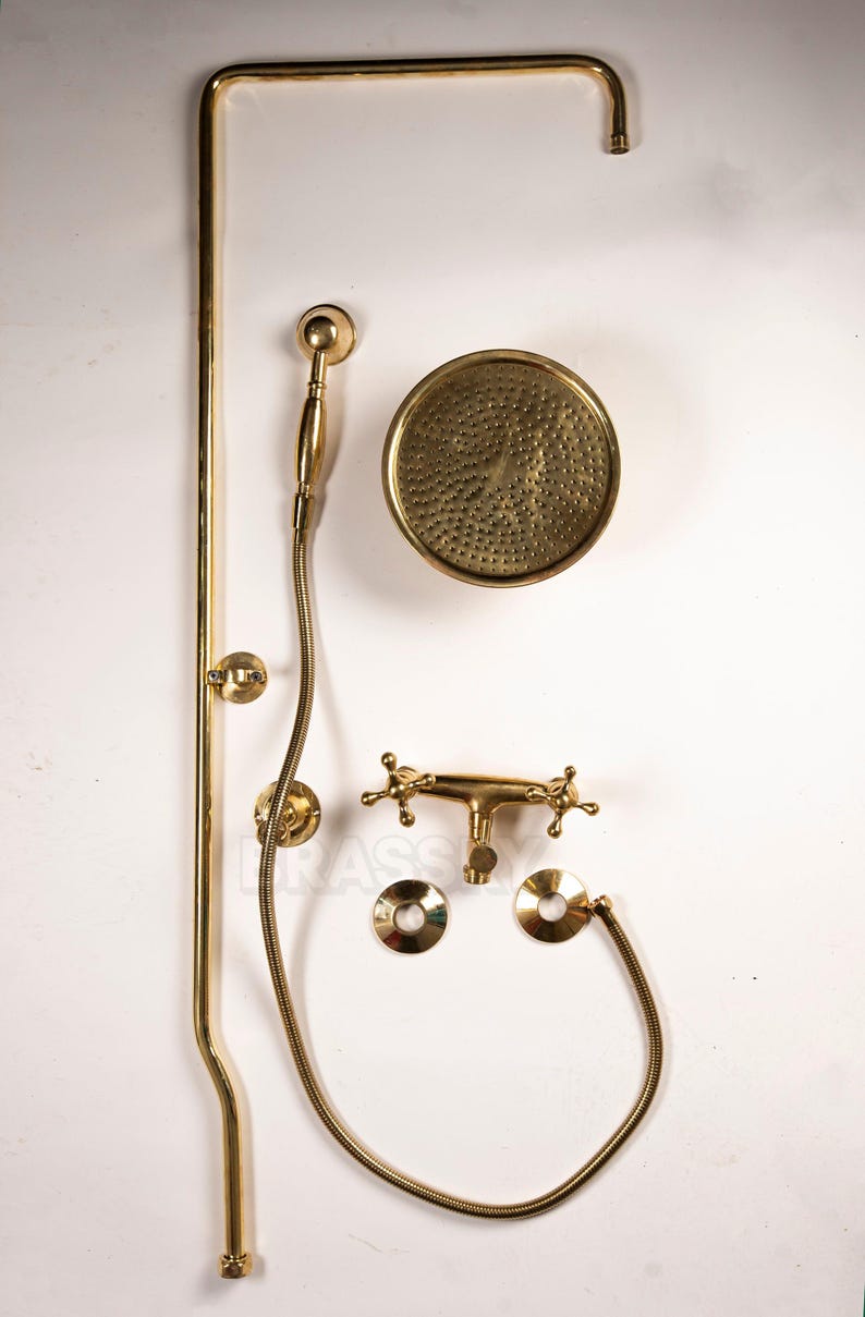Wall-mounted unlacquered brass shower system with rain head and handheld sprayer

