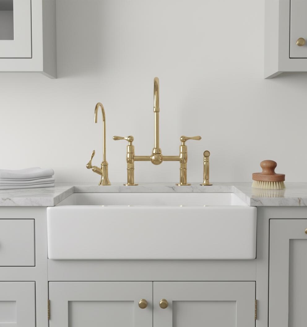 Kitchen sink with gold faucet and fixtures in a gray kitchen setting