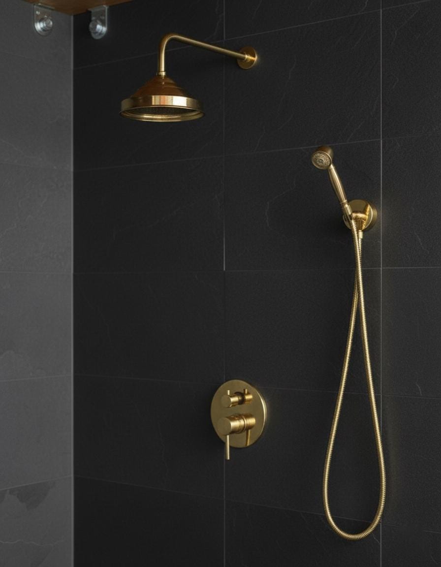 Gold shower head and control valve mounted on a black tiled wall.