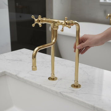 Gold faucet on a marble countertop with a blurred background
