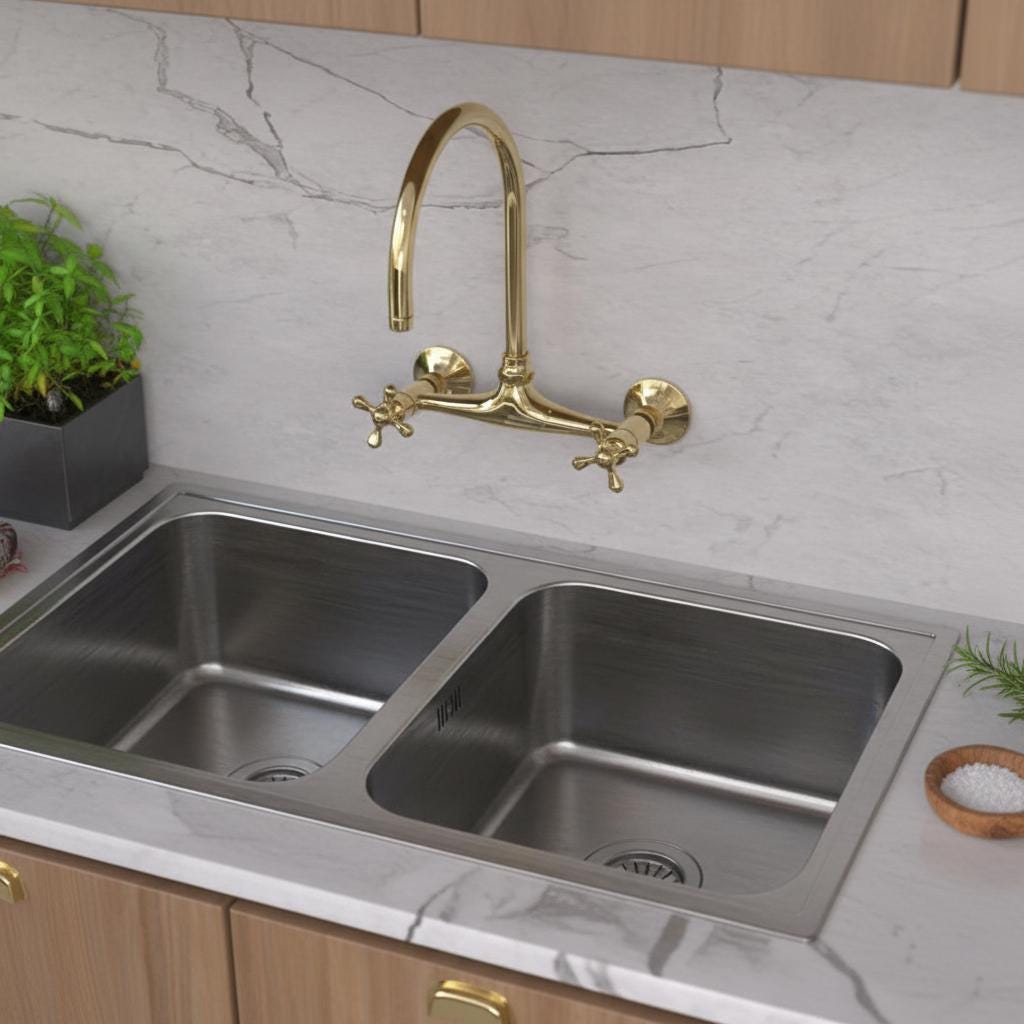 Kitchen sink with gold faucet on a marble countertop