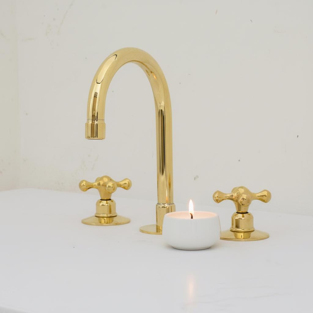 Gold faucet set with two handles on a white background