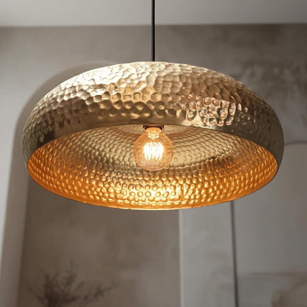 Gold pendant light with a textured surface on a neutral background