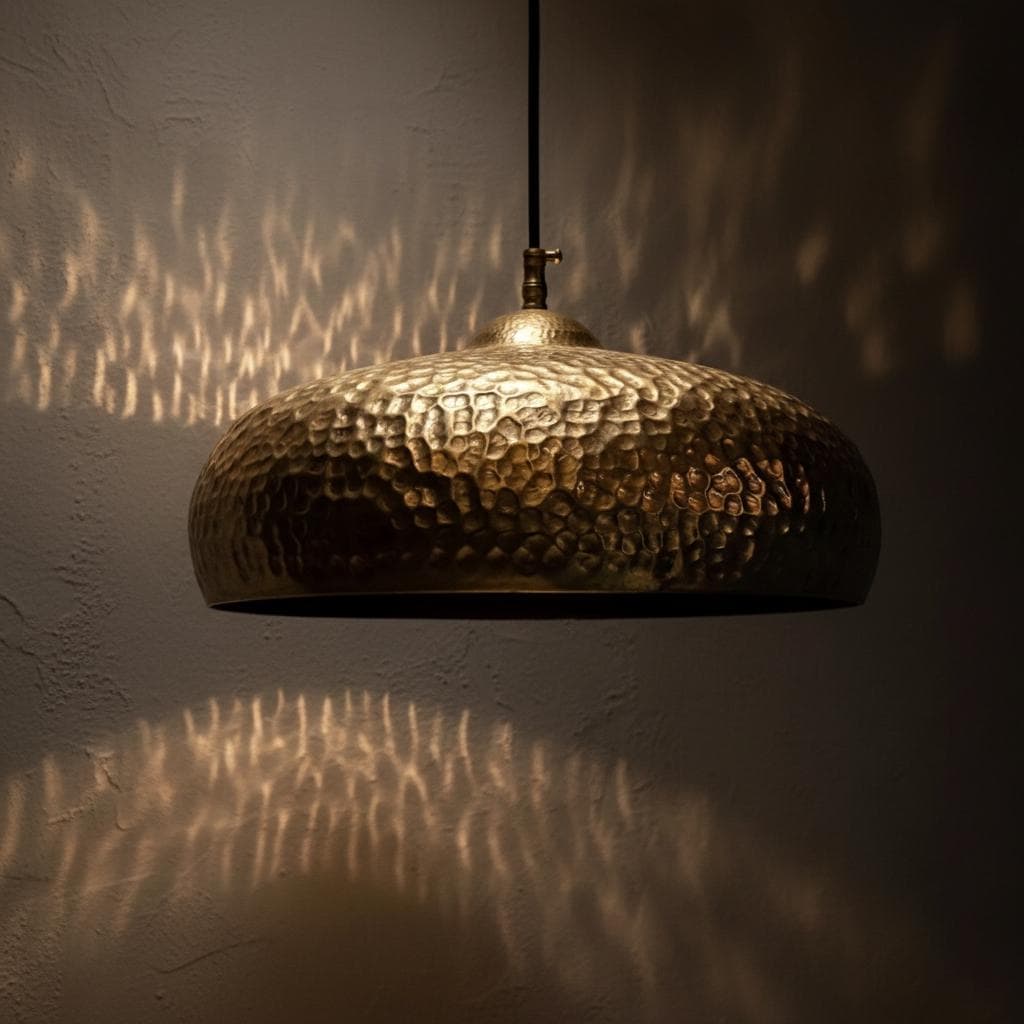 Gold pendant light casting shadows on a wall