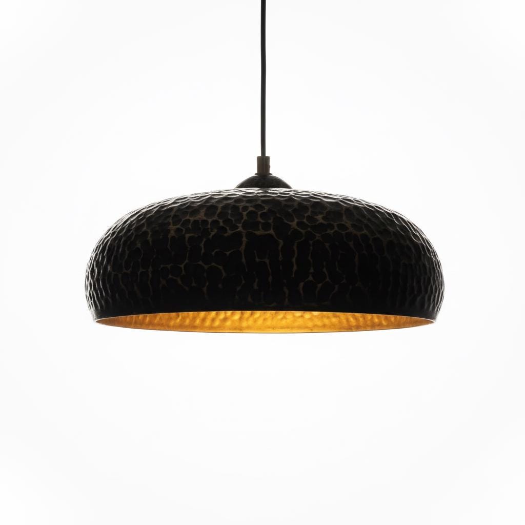 Black pendant light with textured surface and gold interior on a white background