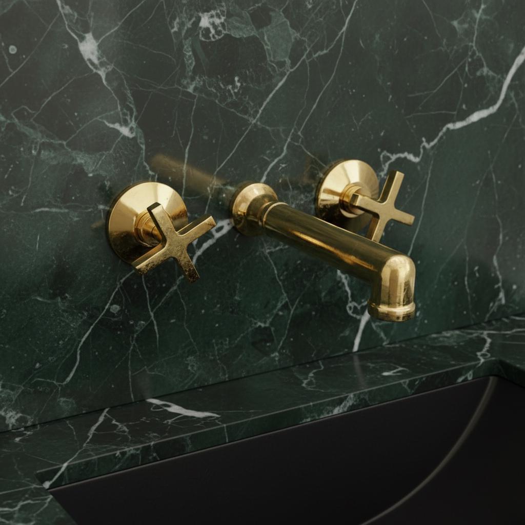 Gold faucet on a green marble wall