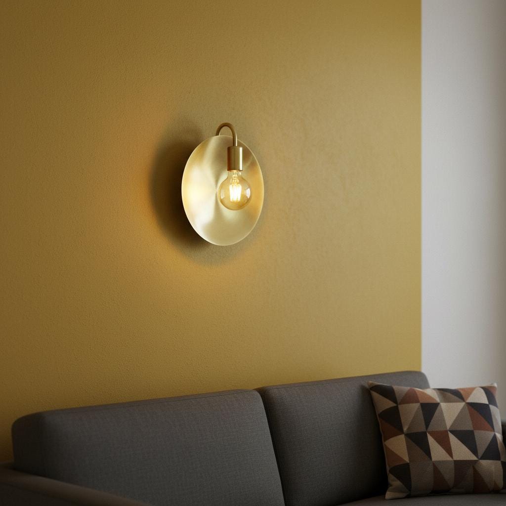 Wall-mounted light fixture on a yellow wall above a gray sofa with a patterned pillow.