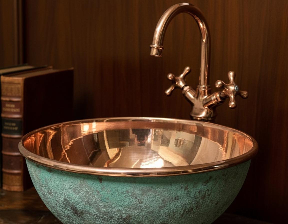 Vintage-style copper sink with faucet against a dark wooden background